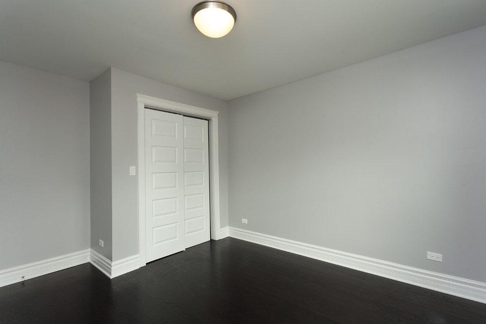 Bild på ett mellanstort funkis sovrum, med grå väggar, mörkt trägolv och brunt golv