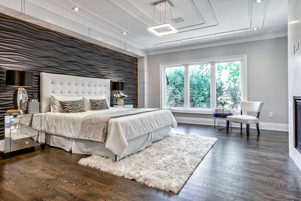 Ispirazione per una camera da letto contemporanea con pareti bianche, pavimento in legno massello medio, camino classico e pavimento marrone