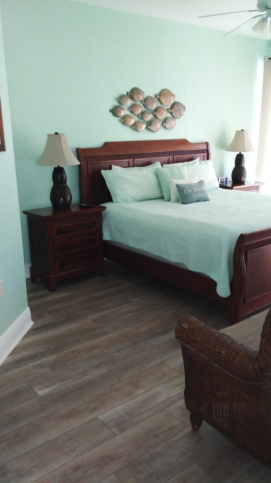 Ejemplo de dormitorio principal marinero grande sin chimenea con paredes azules, suelo de madera oscura y suelo marrón