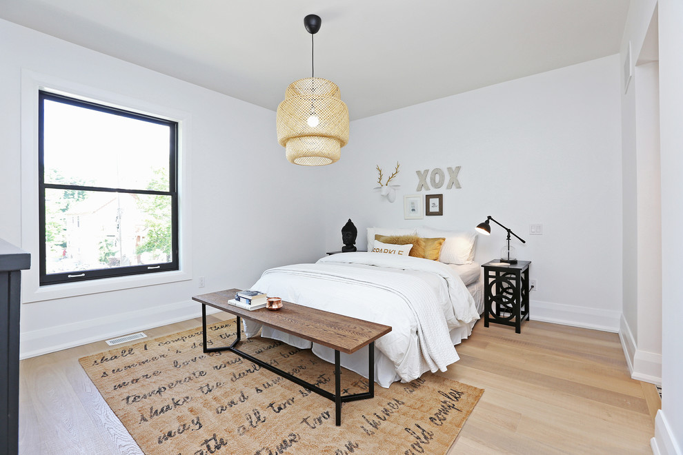 Ejemplo de dormitorio principal nórdico de tamaño medio con paredes blancas, suelo de madera clara y todas las chimeneas