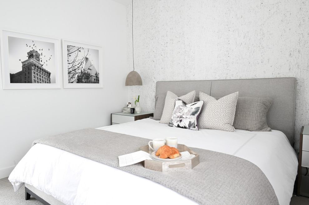 На фото: маленькая хозяйская спальня в современном стиле с белыми стенами, полом из ламината и серым полом без камина для на участке и в саду с