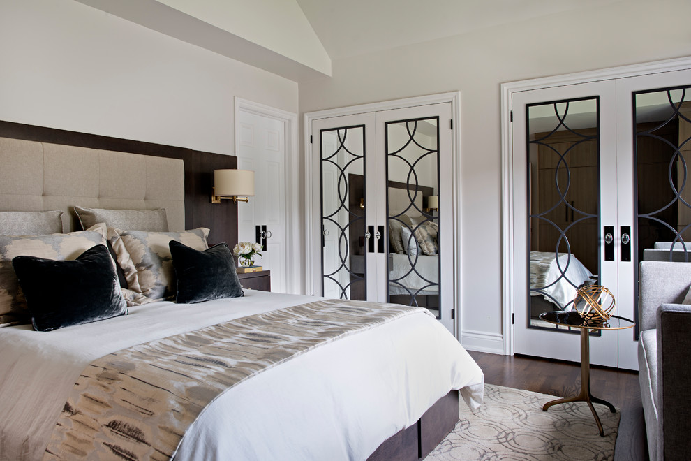 Modelo de dormitorio principal clásico renovado de tamaño medio sin chimenea con paredes blancas, suelo de madera en tonos medios y suelo marrón