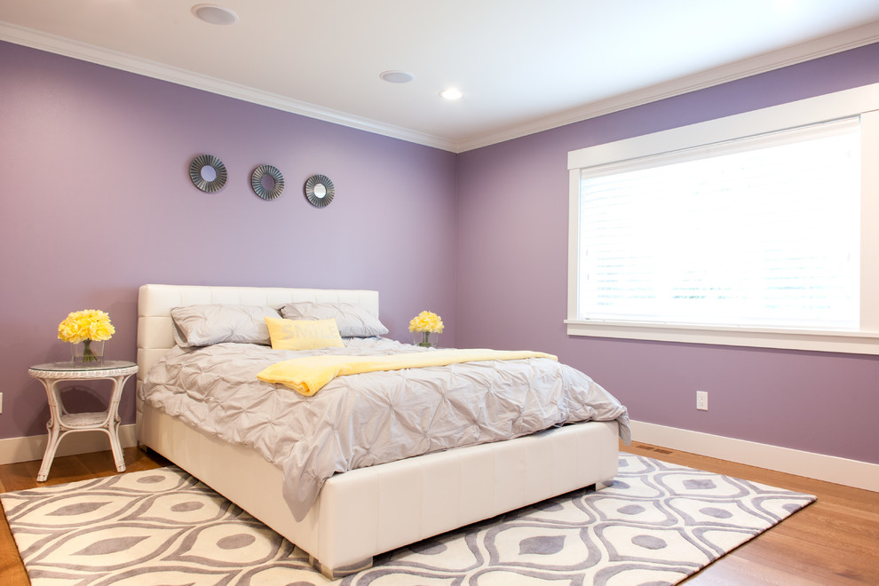 Modelo de habitación de invitados tradicional de tamaño medio sin chimenea con paredes púrpuras y suelo de madera en tonos medios