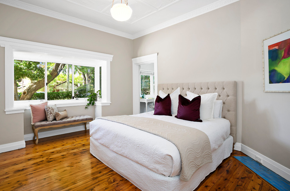 Photo of a medium sized traditional master bedroom in Sydney with beige walls and medium hardwood flooring.