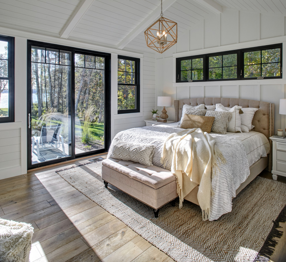 Mittelgroßes Maritimes Hauptschlafzimmer mit weißer Wandfarbe, braunem Holzboden, braunem Boden, freigelegten Dachbalken, Holzdielendecke, gewölbter Decke, Wandpaneelen und Holzdielenwänden in Sonstige