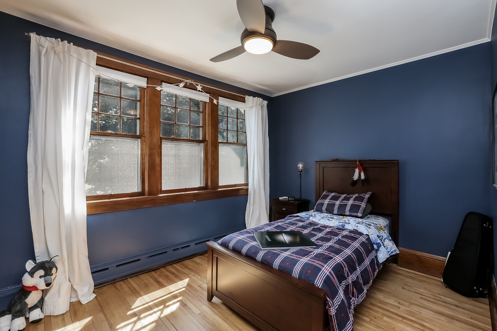 Idée de décoration pour une chambre craftsman de taille moyenne avec un mur bleu et un sol en bois brun.