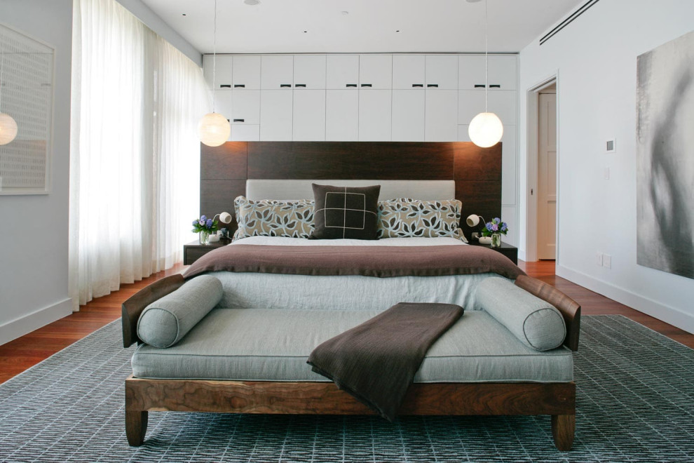 Ispirazione per una camera matrimoniale minimalista di medie dimensioni con pareti beige, pavimento in legno massello medio e nessun camino