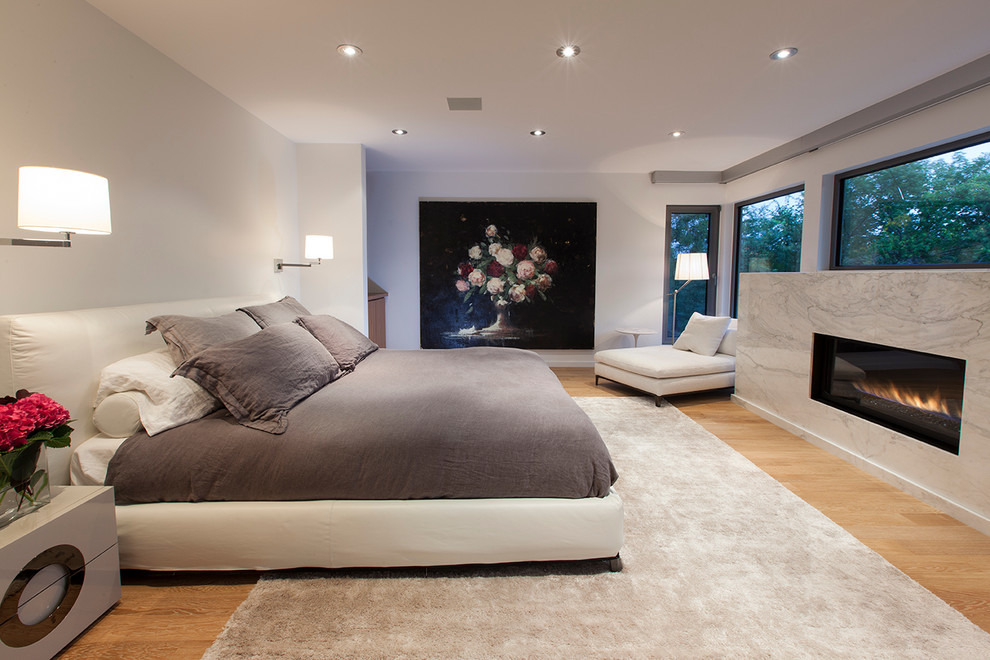 エドモントンにあるコンテンポラリースタイルのおしゃれな寝室 (白い壁、淡色無垢フローリング、横長型暖炉) のインテリア