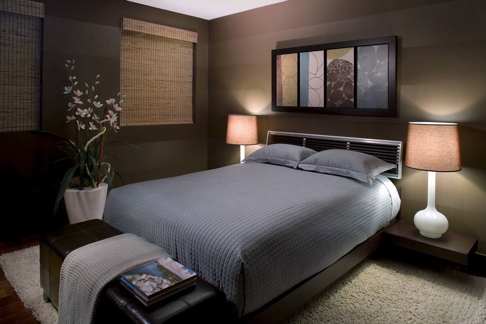 На фото: хозяйская спальня среднего размера в стиле модернизм с коричневыми стенами и темным паркетным полом без камина с