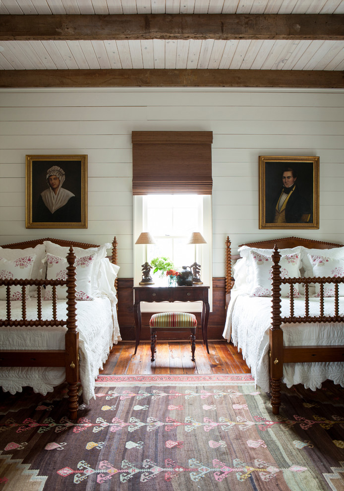 Inspiration for a farmhouse guest bedroom in Atlanta with white walls, medium hardwood flooring and feature lighting.