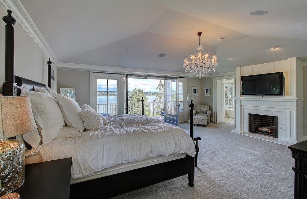 Large elegant master carpeted bedroom photo in Seattle with a standard fireplace, a stone fireplace and gray walls