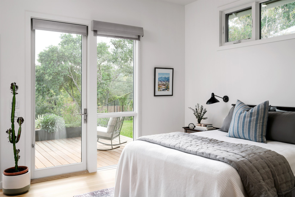 Modelo de habitación de invitados campestre de tamaño medio sin chimenea con paredes blancas y suelo de madera clara