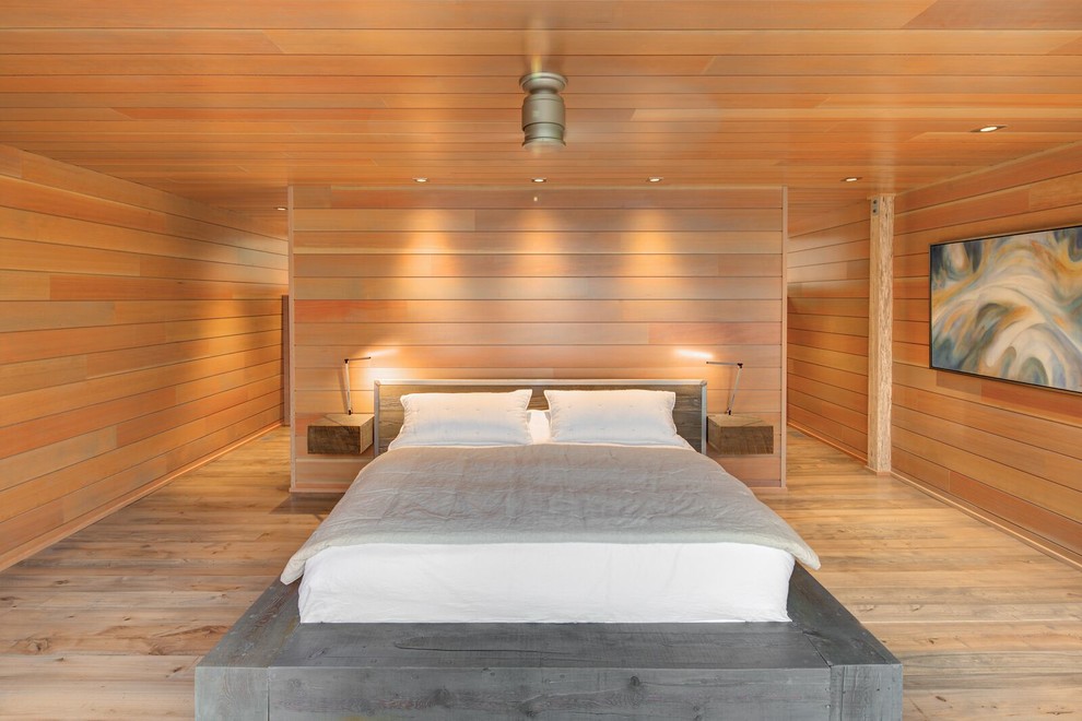 Imagen de dormitorio principal minimalista grande con suelo de madera clara