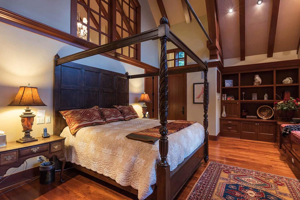 Traditional master bedroom in Sacramento with medium hardwood flooring, a standard fireplace and a stone fireplace surround.