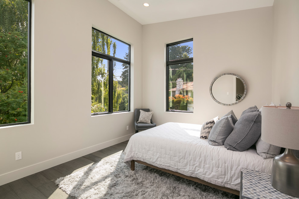 Diseño de habitación de invitados contemporánea de tamaño medio sin chimenea con paredes beige, suelo de madera en tonos medios y suelo marrón
