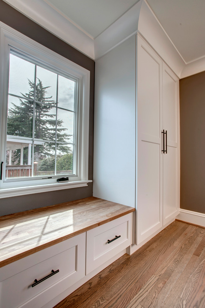 Imagen de dormitorio principal tradicional renovado sin chimenea con paredes grises, suelo de madera clara y suelo beige