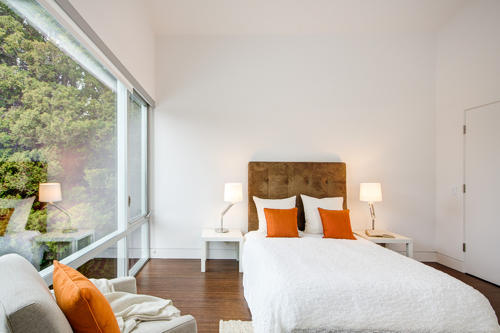 Diseño de dormitorio moderno con paredes blancas y suelo de madera oscura