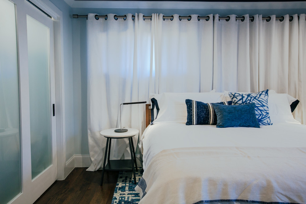 Aménagement d'une petite chambre parentale classique avec un mur bleu, un sol en bois brun et un sol marron.