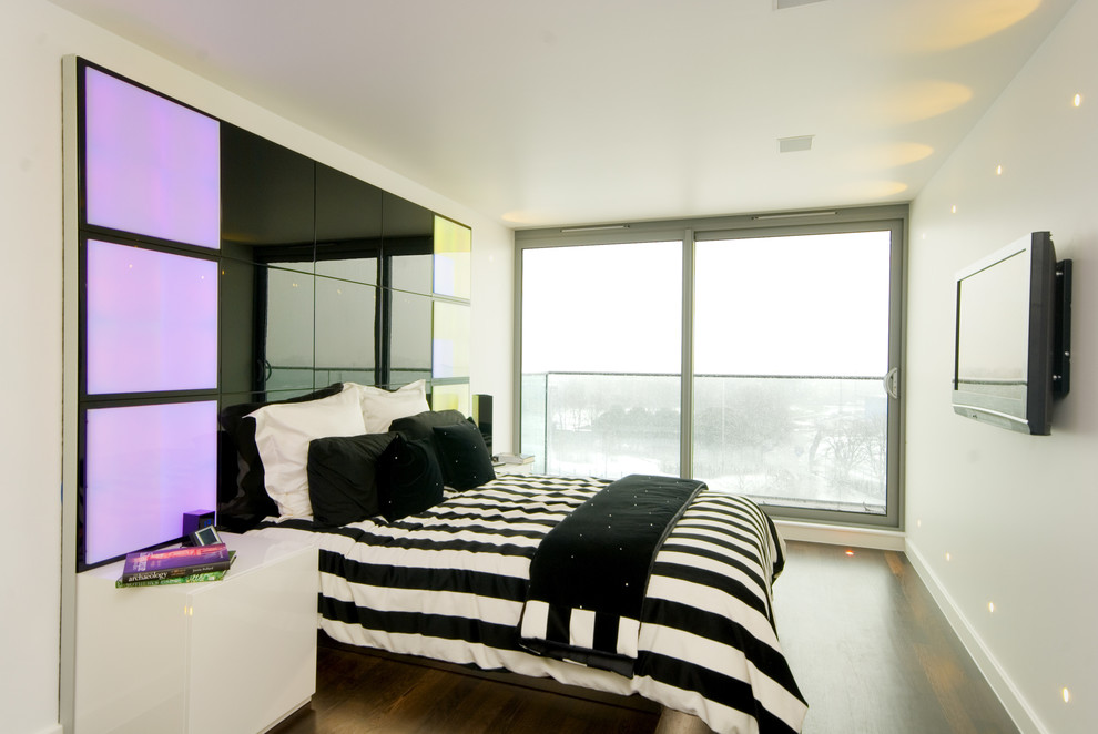Photo of a contemporary bedroom in London with beige walls and dark hardwood flooring.