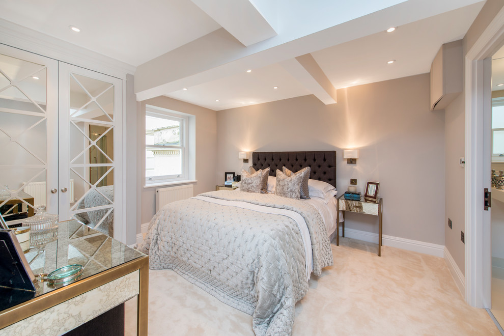This is an example of a small classic master and grey and pink bedroom in London with beige walls and carpet.