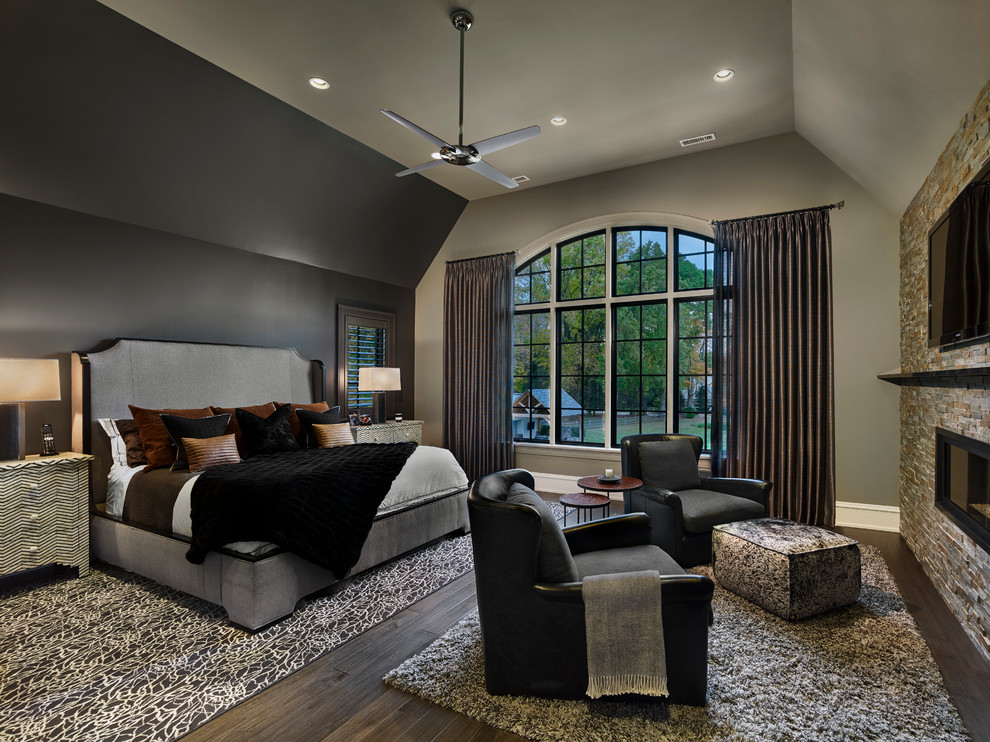 Imagen de dormitorio principal clásico renovado grande con paredes grises, suelo de madera en tonos medios, chimeneas suspendidas y marco de chimenea de baldosas y/o azulejos