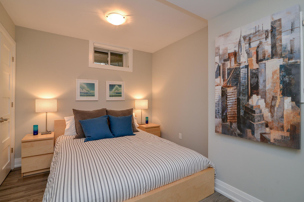 Modelo de habitación de invitados nórdica de tamaño medio sin chimenea con paredes grises, suelo de madera en tonos medios y suelo gris