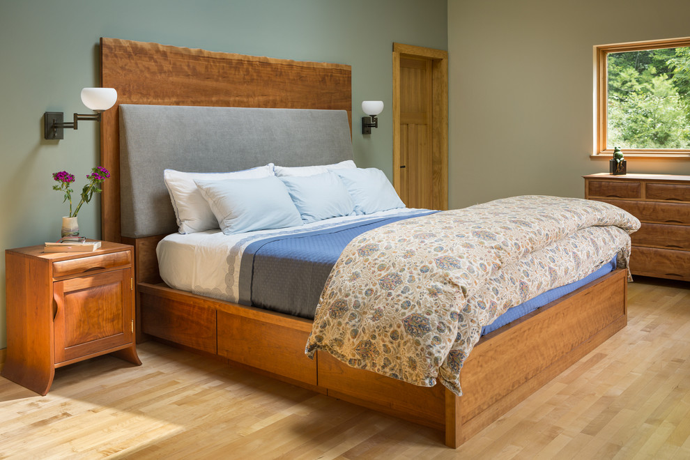 Imagen de dormitorio principal de estilo americano grande sin chimenea con paredes verdes, suelo de madera clara y suelo marrón