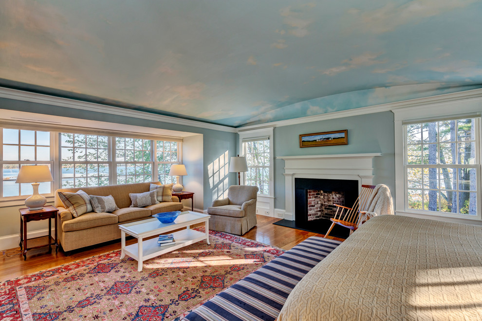 Großes Klassisches Hauptschlafzimmer mit blauer Wandfarbe, hellem Holzboden und Kamin in Burlington