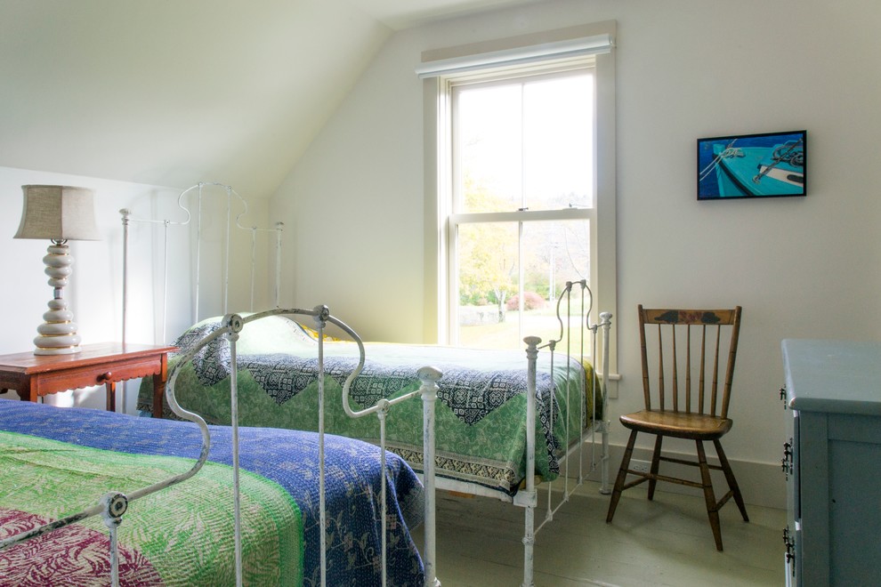 This is an example of a small farmhouse guest bedroom in Portland with white walls and painted wood flooring.