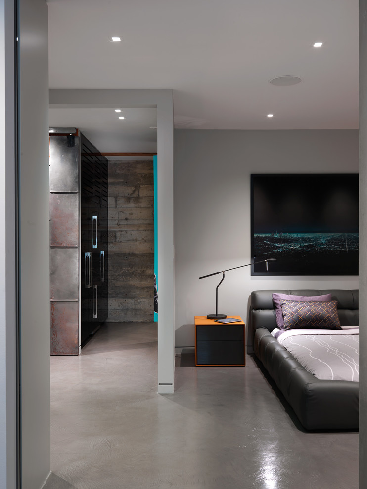 Imagen de dormitorio principal minimalista grande sin chimenea con paredes grises y suelo de cemento