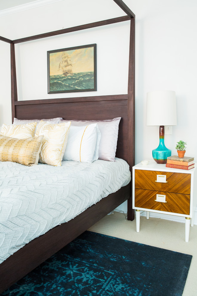 Modelo de dormitorio principal costero de tamaño medio con paredes blancas y moqueta