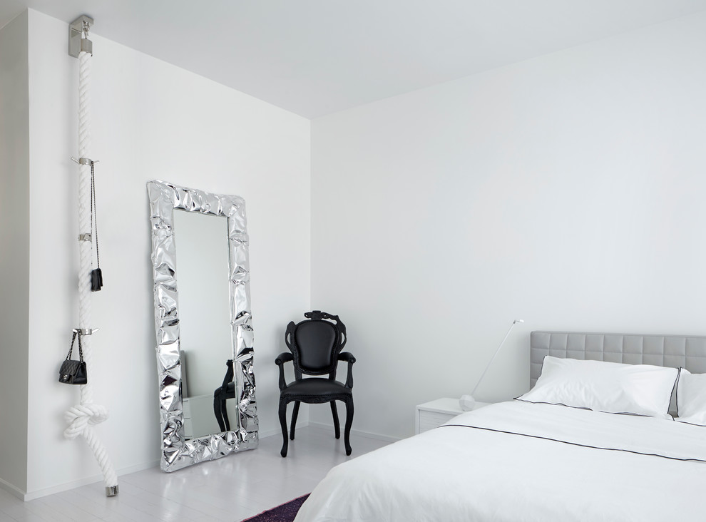 На фото: спальня в современном стиле с белыми стенами и деревянным полом