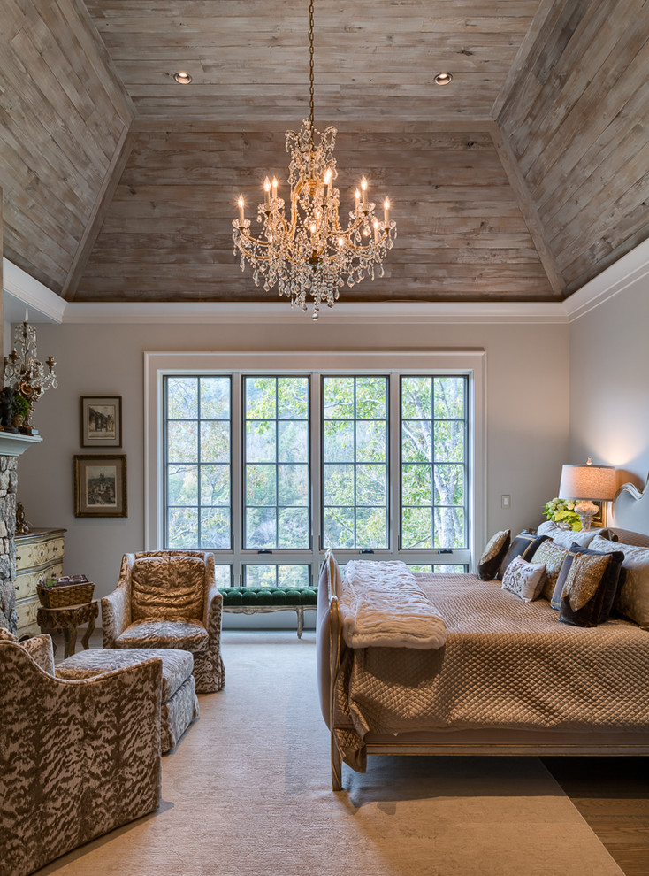 Inspiration pour une chambre traditionnelle avec un mur blanc, un sol en bois brun, une cheminée standard, un manteau de cheminée en pierre et un sol marron.
