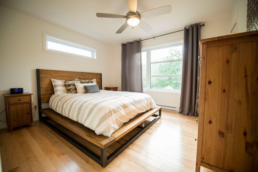 Medium sized classic guest bedroom in Montreal with white walls and light hardwood flooring.