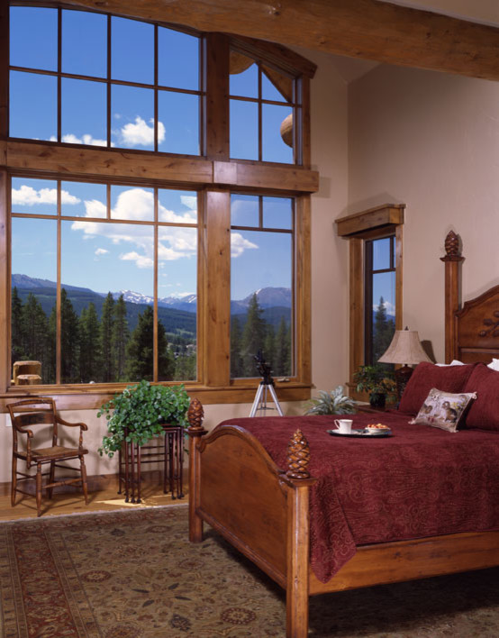 Mid-sized mountain style guest light wood floor and brown floor bedroom photo in Denver with beige walls and no fireplace