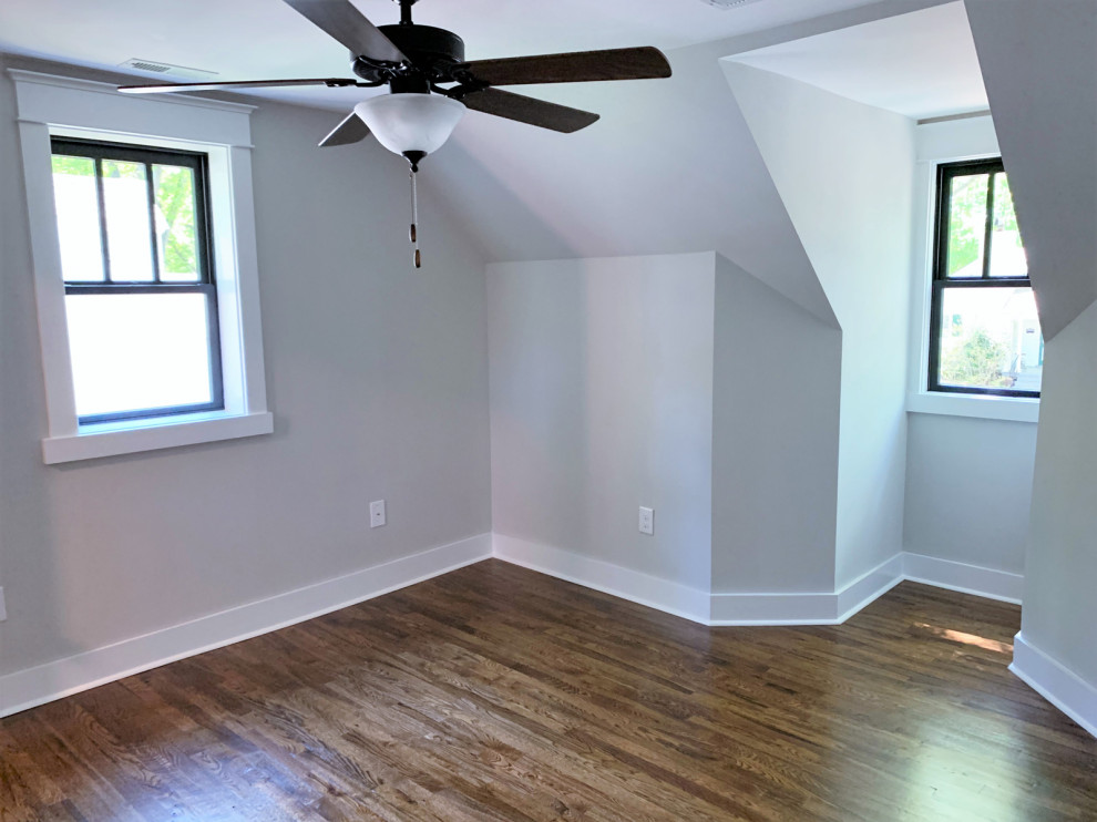 Exemple d'une chambre d'amis chic de taille moyenne avec un mur gris, un sol en bois brun et un sol marron.