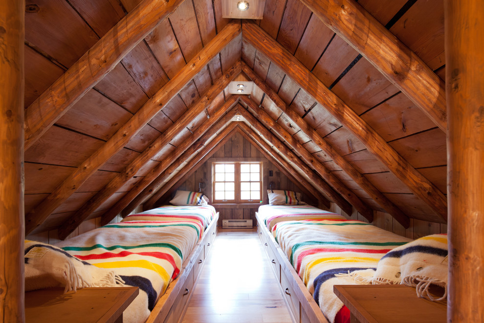 Cette image montre une chambre d'amis chalet de taille moyenne avec un mur marron, un sol en bois brun et aucune cheminée.