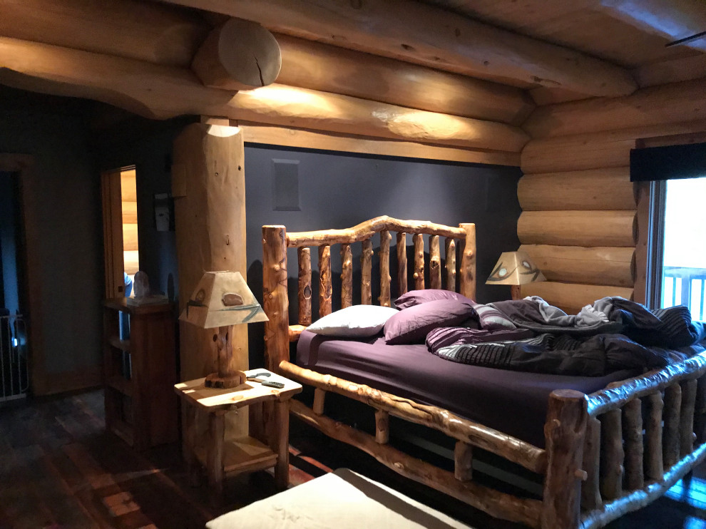 Foto de dormitorio principal tradicional de tamaño medio con paredes púrpuras, suelo de madera oscura, todas las chimeneas, marco de chimenea de madera, suelo marrón, madera y vigas vistas