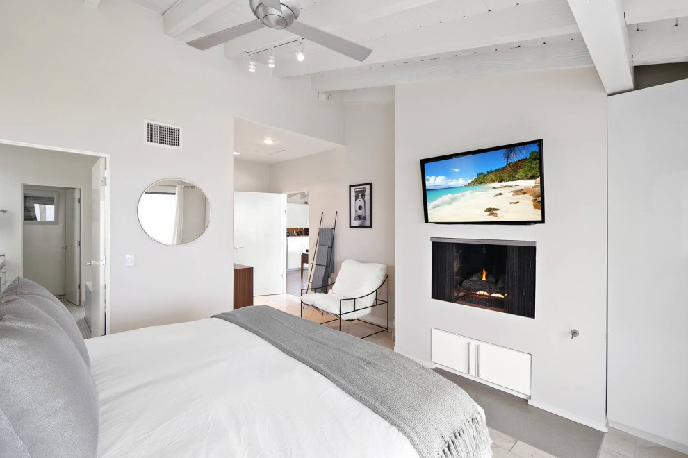 Пример оригинального дизайна: хозяйская спальня среднего размера в морском стиле с серыми стенами, полом из известняка, стандартным камином, фасадом камина из штукатурки и бежевым полом