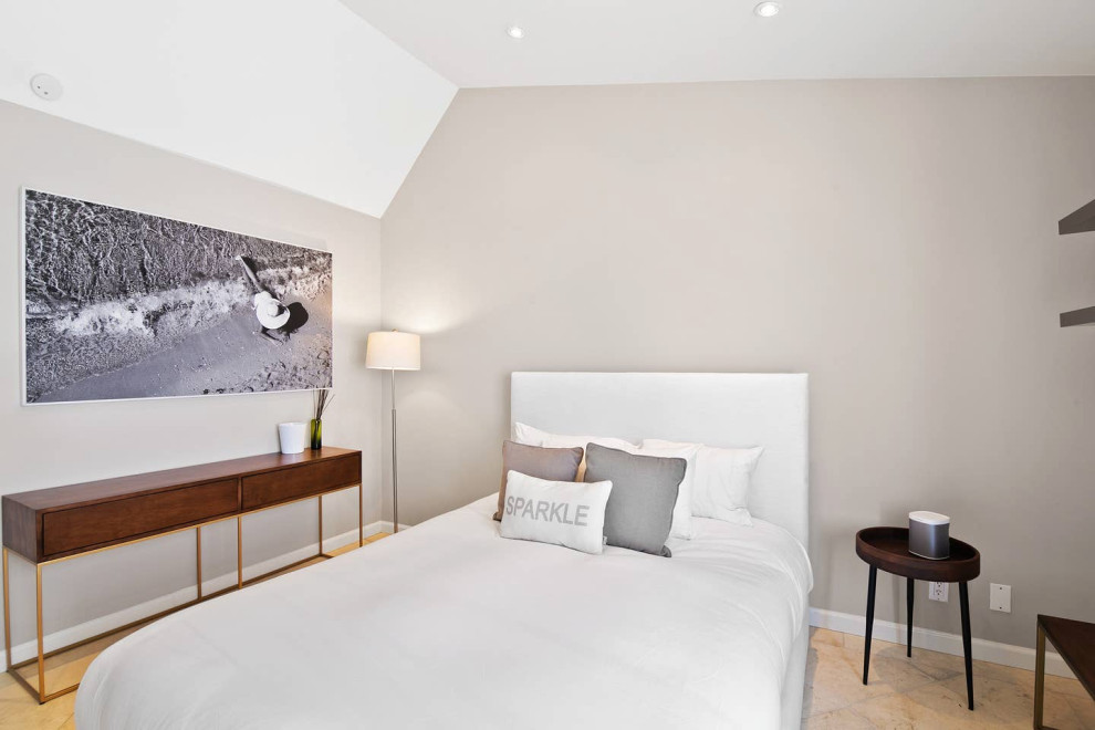 Imagen de habitación de invitados costera de tamaño medio sin chimenea con paredes grises, suelo de piedra caliza y suelo gris
