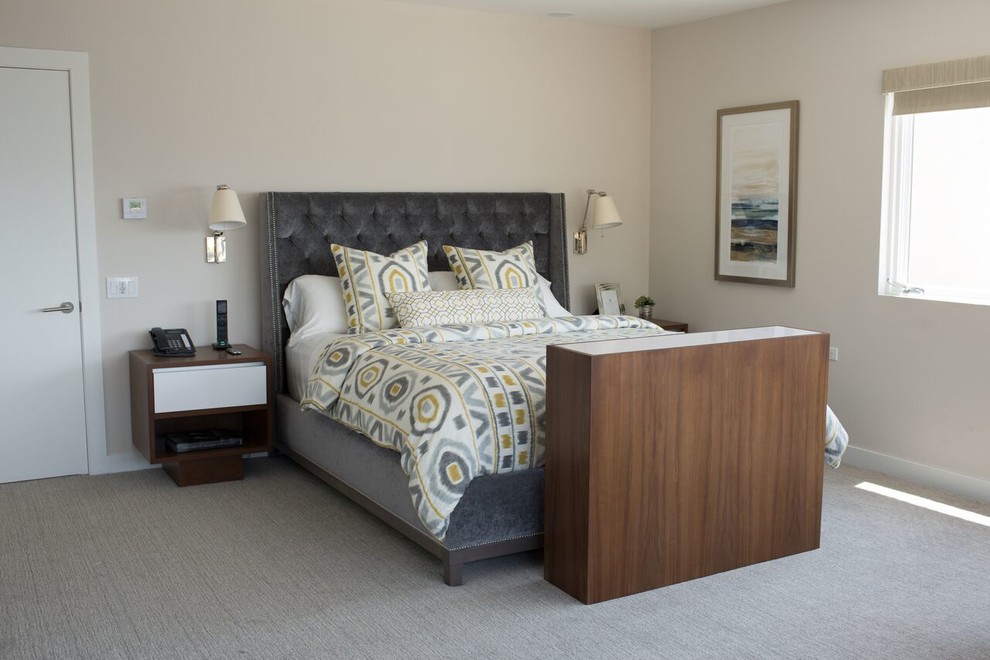 This is an example of a large traditional master bedroom in Los Angeles with beige walls, carpet and grey floors.
