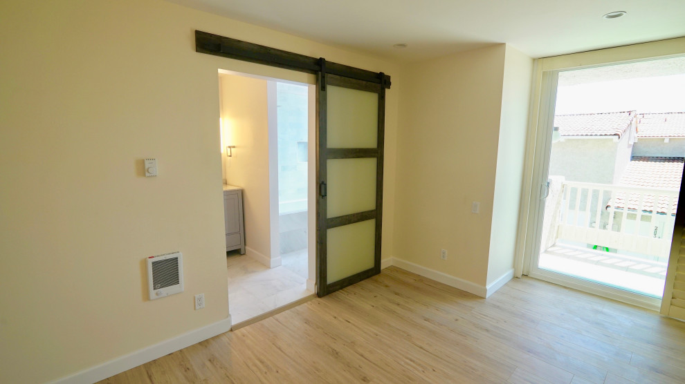 Ejemplo de dormitorio principal moderno de tamaño medio sin chimenea con paredes beige, suelo de madera clara y suelo beige