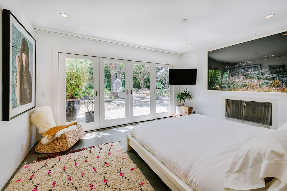 Design ideas for a medium sized eclectic master bedroom in Los Angeles with white walls, concrete flooring and a standard fireplace.