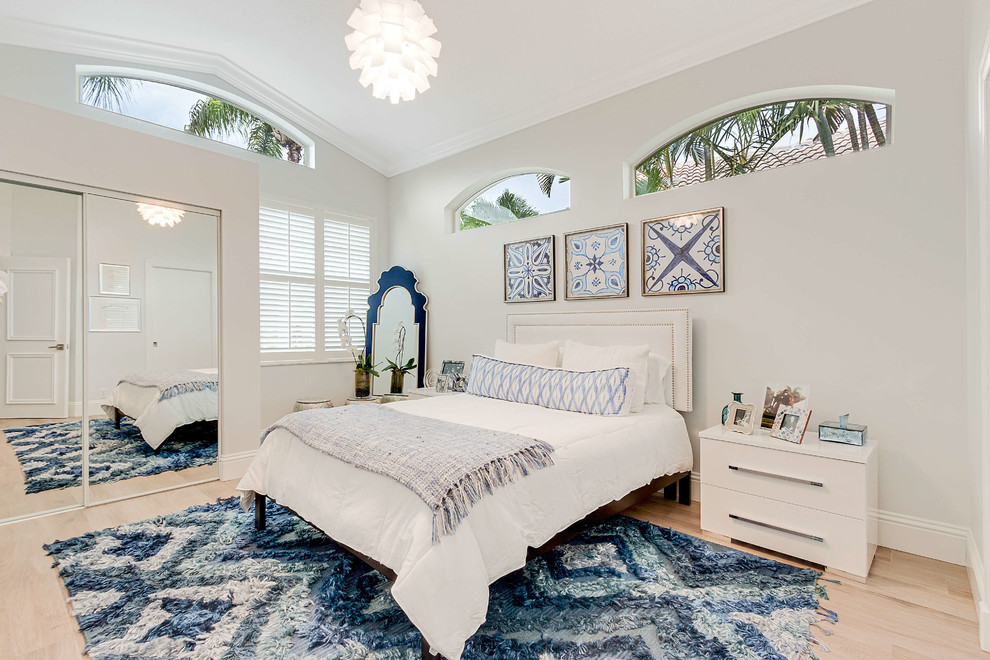 Klassisches Schlafzimmer mit weißer Wandfarbe, hellem Holzboden und beigem Boden in Miami
