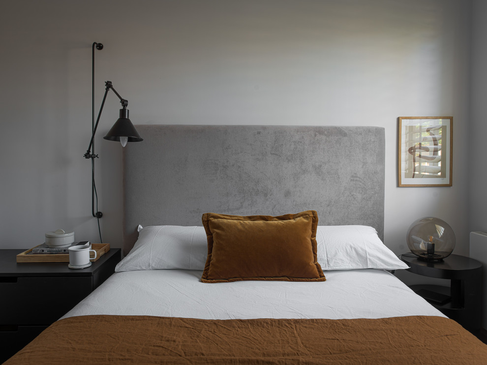 Ejemplo de habitación de invitados nórdica de tamaño medio sin chimenea con paredes grises, suelo de madera oscura y suelo marrón