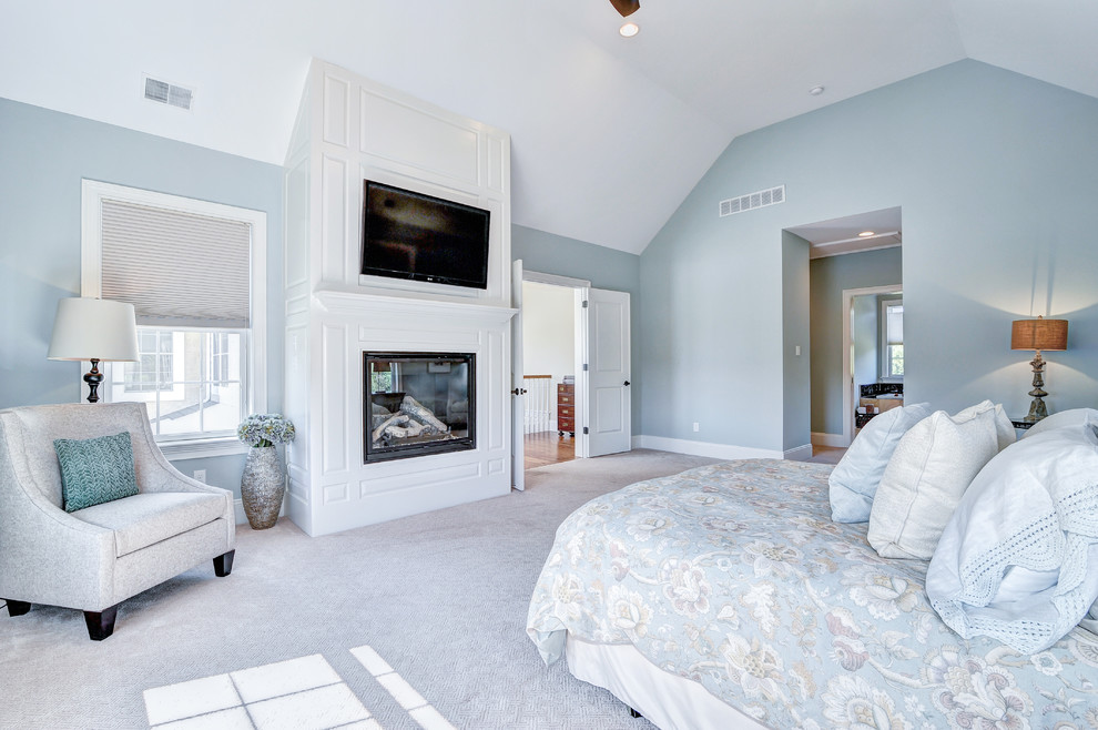 Пример оригинального дизайна: огромная хозяйская спальня в классическом стиле с синими стенами, ковровым покрытием, стандартным камином и фасадом камина из дерева