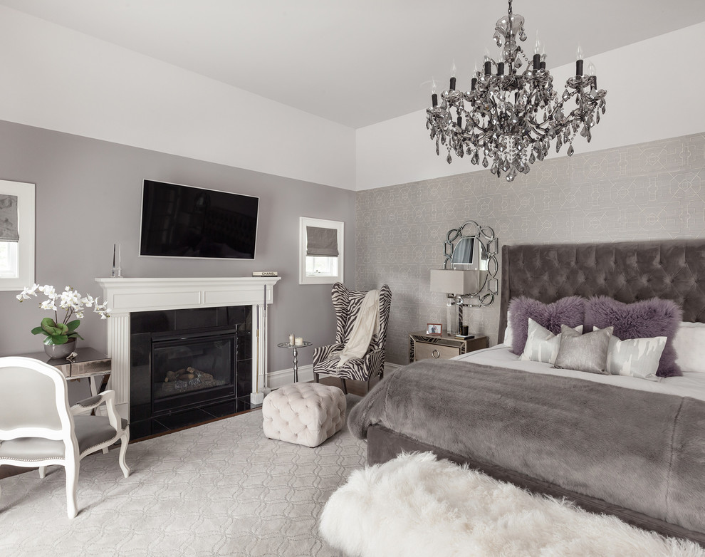 Imagen de dormitorio principal tradicional grande con paredes grises, suelo de madera en tonos medios, todas las chimeneas y marco de chimenea de baldosas y/o azulejos