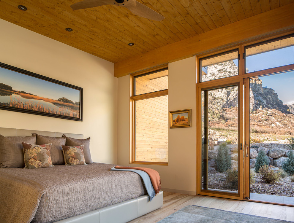 Großes Modernes Hauptschlafzimmer ohne Kamin mit beiger Wandfarbe und hellem Holzboden in Denver