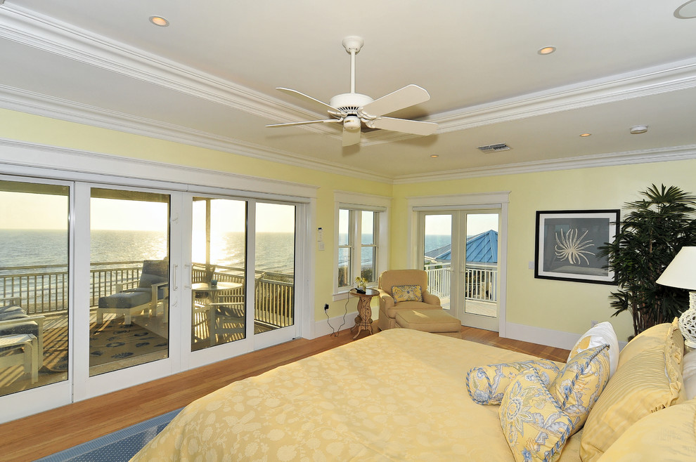 Large beach style master light wood floor bedroom photo in Other with yellow walls
