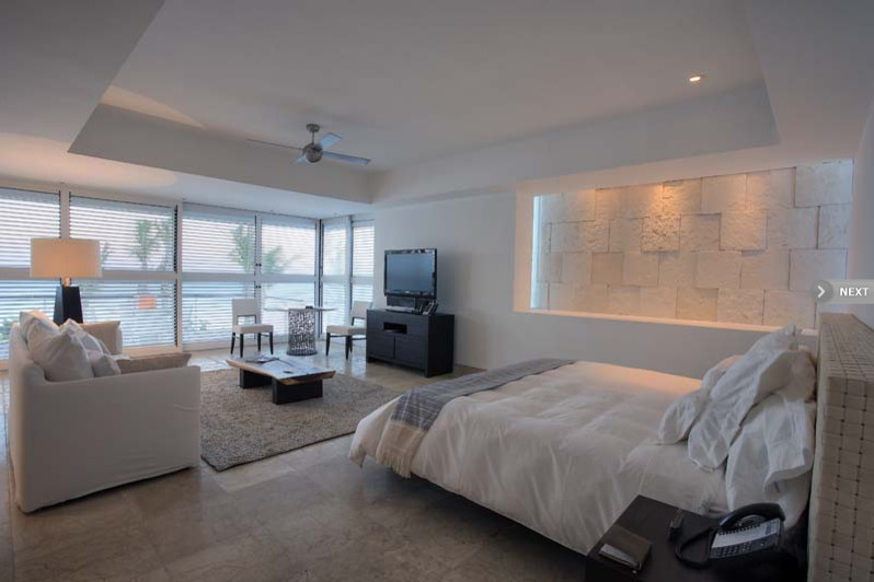 Design ideas for a large contemporary master bedroom in Miami with white walls, limestone flooring and no fireplace.